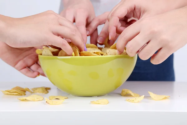 Hands of people take chips from bowl — Stock Photo, Image