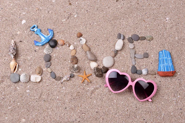 Wortliebe aus Muscheln und Steinen auf Sand — Stockfoto