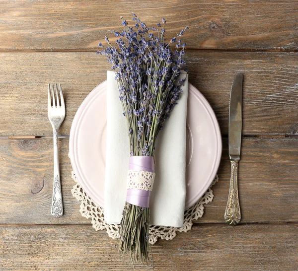 Сервировка обеденного стола с цветами лаванды на фоне деревянного стола — стоковое фото