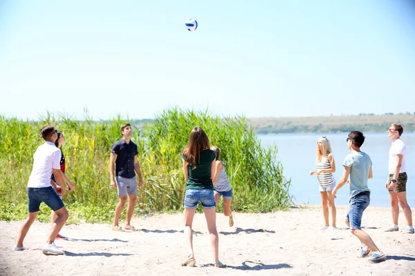 Vackra unga människor spela volleyboll på stranden — Stockfoto