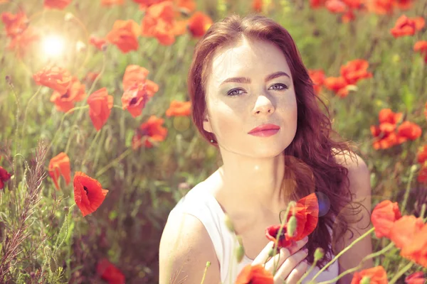 Beautiful young woman in poppy field — Stock Photo, Image