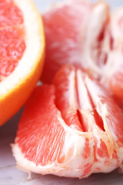 Pomelos maduros sobre tabla de cortar, sobre fondo de madera — Foto de Stock