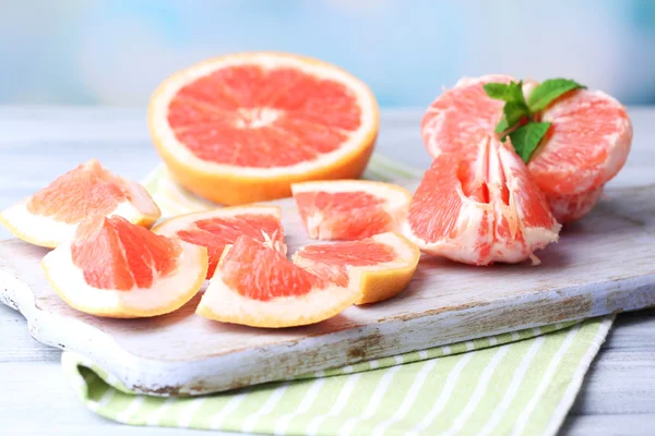 Zralých grapefruitů na prkénko, na dřevěný stůl, na světlé pozadí — Stock fotografie