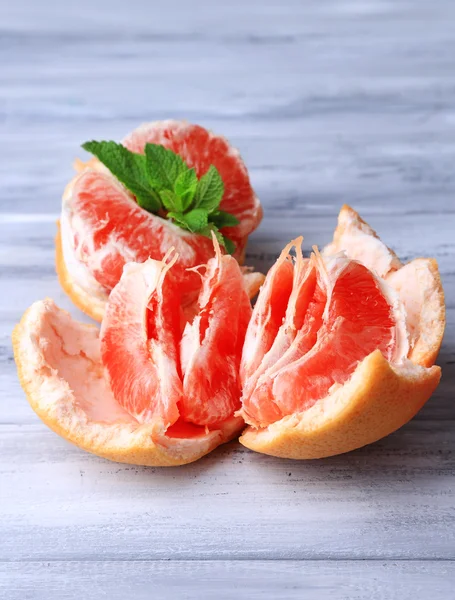Zralé oloupané grapefruitů na barevné dřevěné pozadí — Stock fotografie