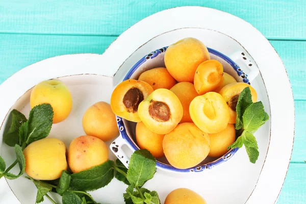 Ripe apricots with green mint leaves — Stock Photo, Image