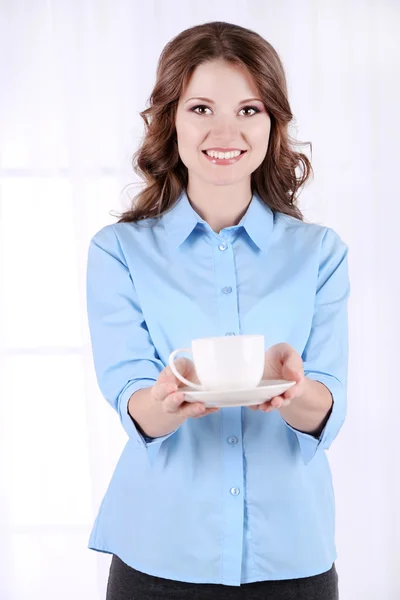 Молодая деловая женщина с чашкой в комнате — стоковое фото