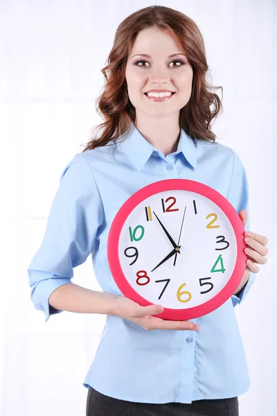 Młody biznes kobieta z zegara w pokoju — Zdjęcie stockowe