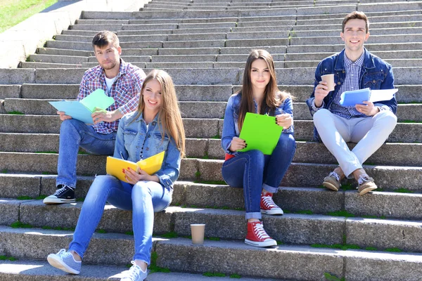Studenti sedí na schodech v parku — Stock fotografie