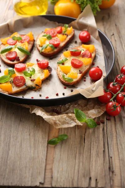 Bruschetta with tomatoes on pan — Stock Photo, Image