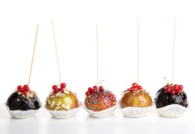 Sweet caramel apples on sticks with berries clipart