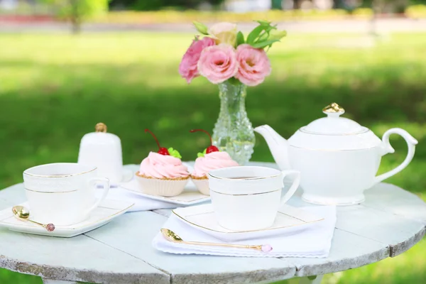 Mesa de centro con tazas de té y pasteles — Foto de Stock