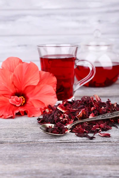 Hibiscus tea in glass teapot and flower — Stock Photo, Image