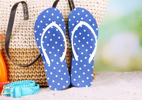 Bolsa de mimbre de verano con accesorios en arena — Foto de Stock