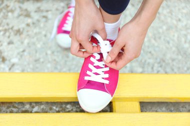 Genç kadın bağlama ayakkabı bağı