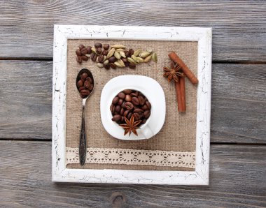 Baharat ahşap arka plan üzerinde beyaz kupa, kahve taneleri ile ahşap çerçeve