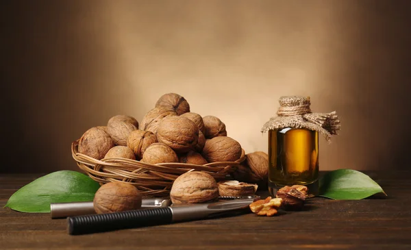 Aceite de nuez y nueces sobre mesa de madera — Foto de Stock