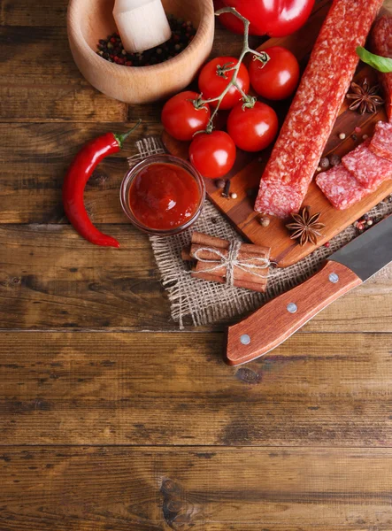 Savoureux saucisson salami et épices sur fond de bois — Photo