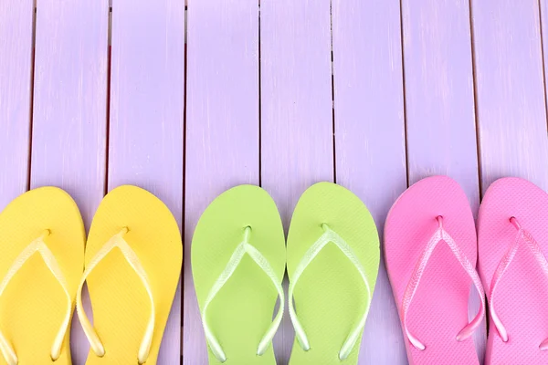 Bright flip-flops on color wooden background — Stock Photo, Image