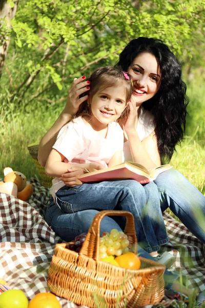 Happy mom and daughter. Picnic in the green park — Stock Photo, Image