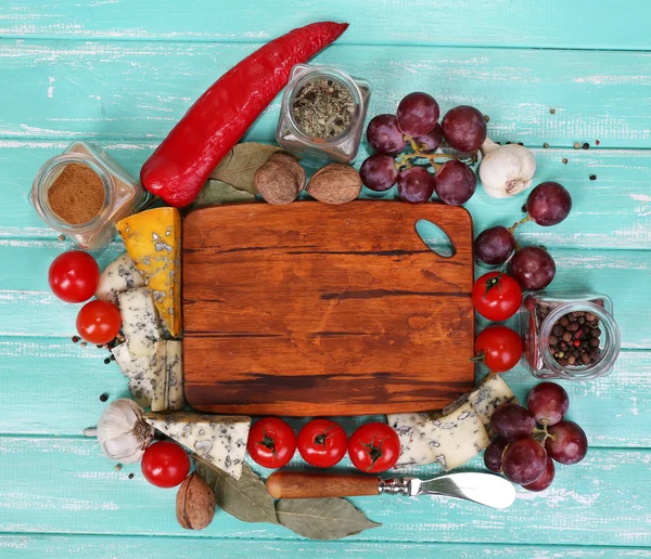 Different types of cheese with empty board on table close-up — Stock Photo, Image