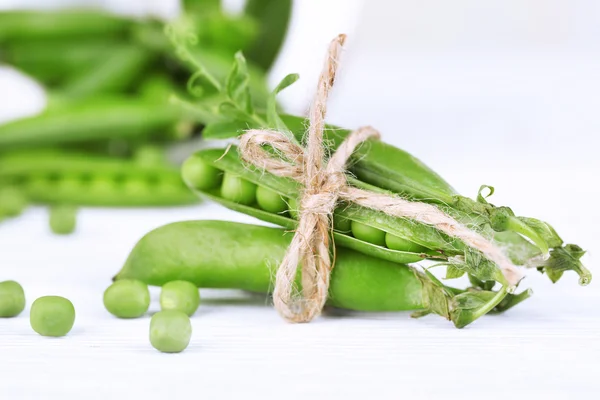 Guisantes verdes frescos en mesa de madera —  Fotos de Stock