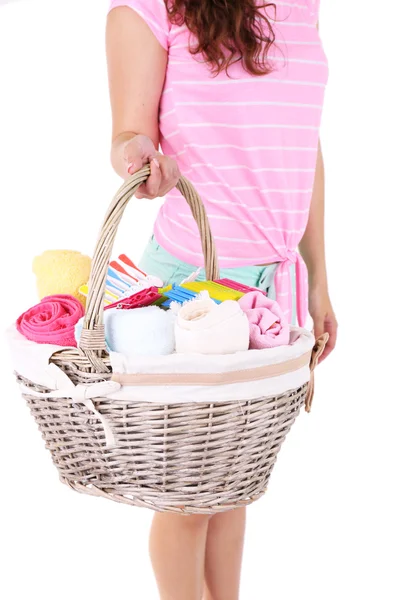 Woman holding laundry basket with clean clothes, towels and pins, isolated on white — Stock Photo, Image