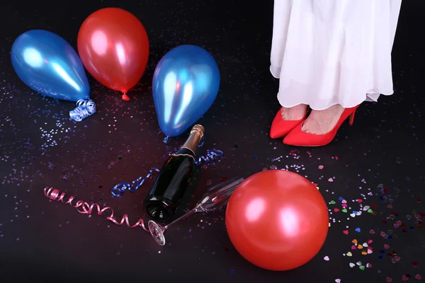 Jambes avec confettis, champagne et ballons — Photo