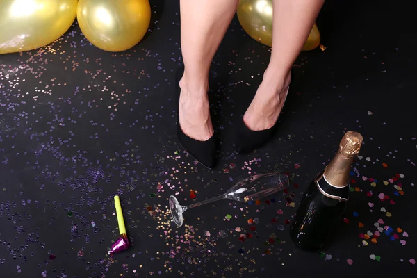 Jambes avec confettis, champagne et ballons — Photo