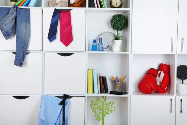 Hermosos cajones blancos y estantes con diferentes objetos relacionados con el hogar. concepto de habitación masculina — Foto de Stock