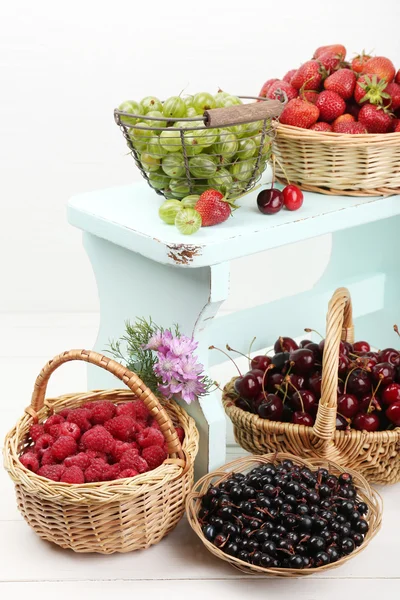 Čerstvé plody v koších na bílé zdi pozadí — Stock fotografie