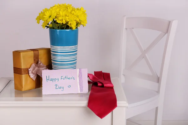 Bouquet of flowers, gift box and tie on Fathers Day in room — Stock Photo, Image