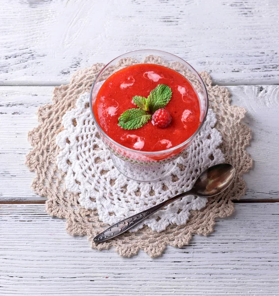 Smoothies aux fraises, aux kiwis et aux framboises dans un bol en verre sur fond de bois de couleur — Photo