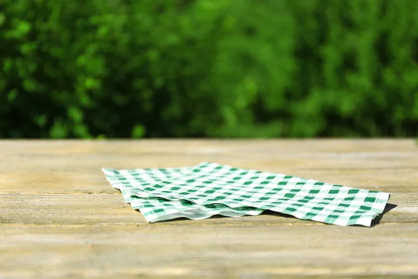 Mesa de madeira com toalha de mesa, ao ar livre — Fotografia de Stock