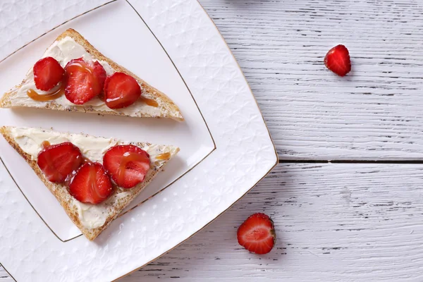 Toast frais au beurre fait maison et fraise fraîche sur fond de bois — Photo