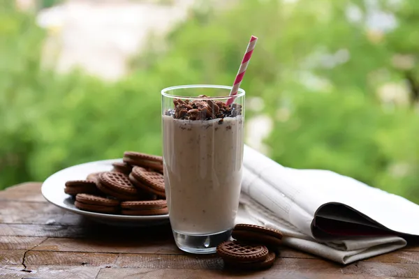 牛奶鸡尾酒玻璃和巧克力饼干上自然背景表格 — 图库照片