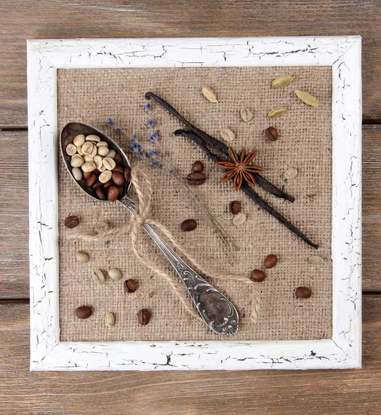 Wooden frame, vintage spoon and spices on wooden background — Stock Photo, Image