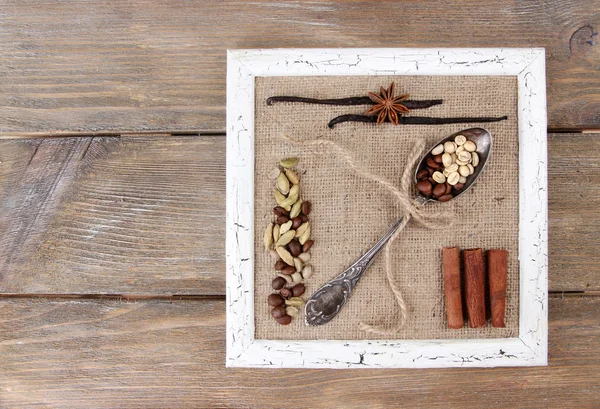 Wooden frame, vintage spoon and spices on wooden background — Stock Photo, Image