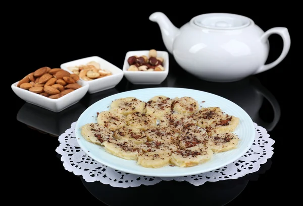 Sweetened fried banana on plate on black background, close-up — Stock Photo, Image