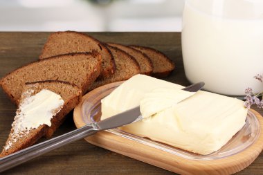Ahşap kutusunda ekmek ve süt penceresi arka plan üzerinde ahşap masa üzerinde çevrili tereyağı