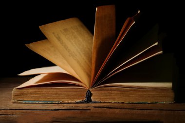 siyah arka plan üzerine masada eski kitap