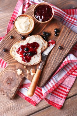 taze ekmek ile ev yapımı tereyağı ve blackcurrant jam ahşap arka plan üzerinde