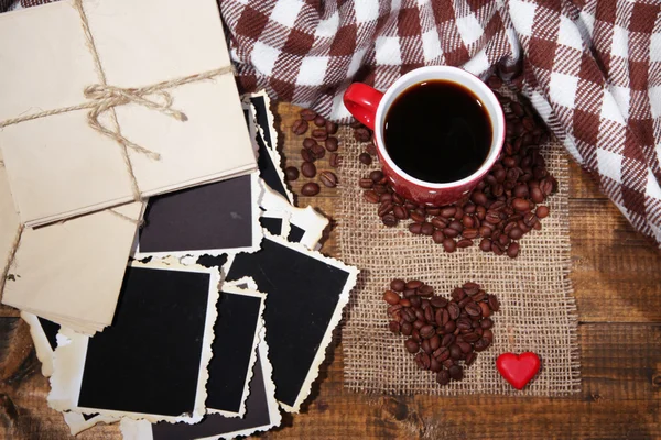 Composición con taza de café, corazones decorativos, especias a cuadros y viejas fotos en blanco, sobre fondo de madera —  Fotos de Stock