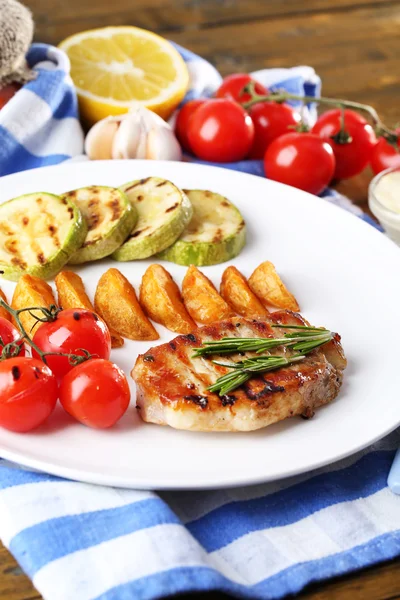 Filete a la parrilla, verduras a la parrilla y patatas fritas en el fondo de la mesa — Foto de Stock
