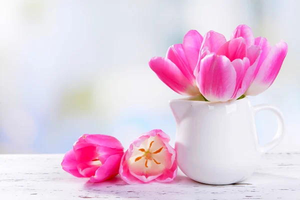 Beautiful tulips in bucket in vase on table on light background — Stock Photo, Image