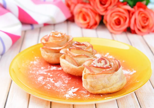 ขนมปังพัฟอร่อยกับดอกกุหลาบรูปแอปเปิ้ลบนจานบนโต๊ะใกล้ชิด — ภาพถ่ายสต็อก