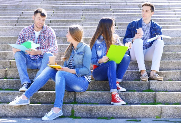 Studenti sedí na schodech v parku — Stock fotografie