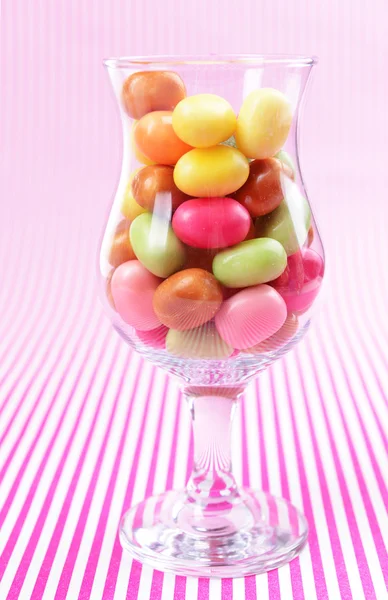 Different colorful fruit candy in glass on pink background — Stock Photo, Image