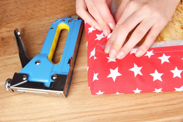 Fastening fabric and board using construction stapler — Stock Photo, Image