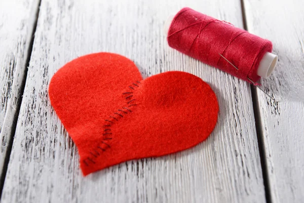 Broken heart and thread on wooden background — Stock Photo, Image