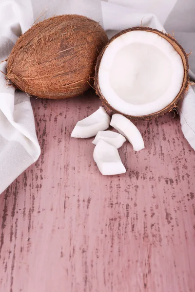 Gebroken kokosnoot met servet op houten achtergrond — Stockfoto